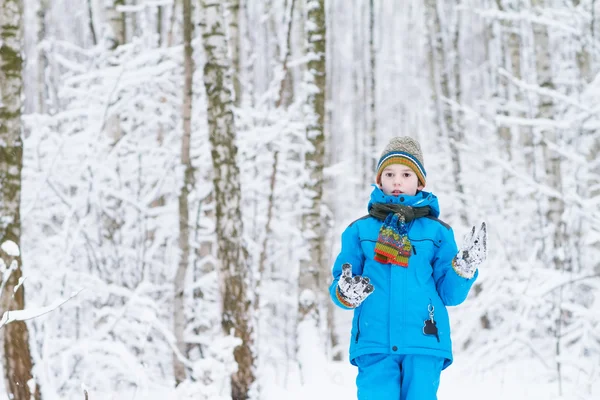 Pojke leker med snö i en winter park — Stockfoto