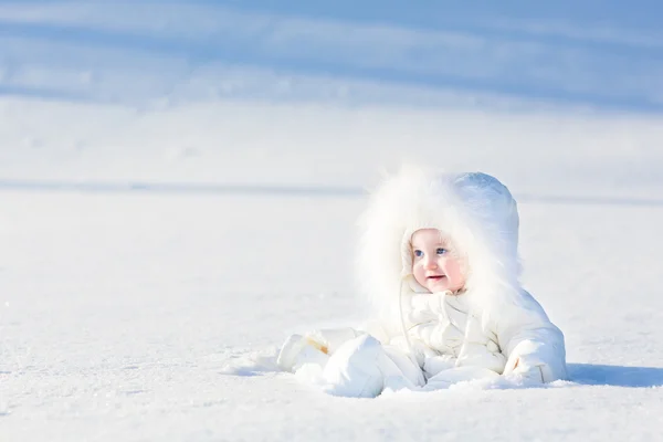 Little baby girl sitting in white snow — Stock Photo, Image