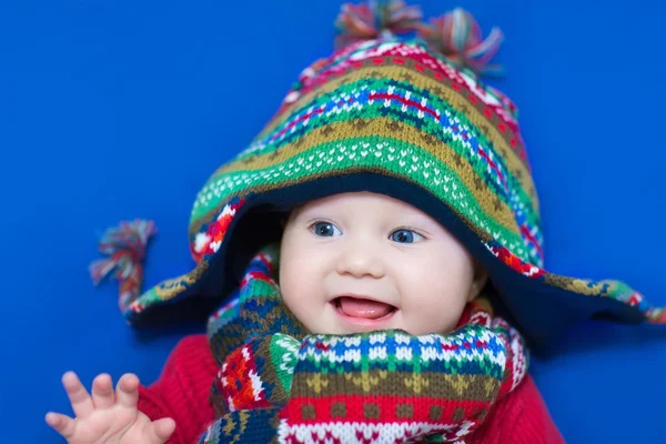 Baby girl in a big knitted hat and colorful scarf — Stock Photo, Image