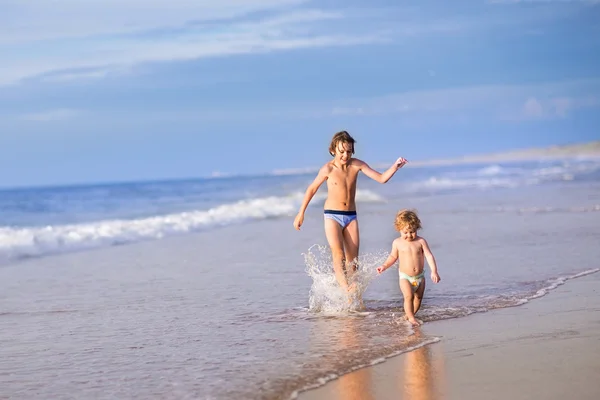 小女孩和她的弟弟，美丽的海滩上 — 图库照片