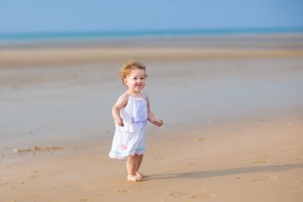 Baby girl wearing walking on the beach — Stock Photo, Image