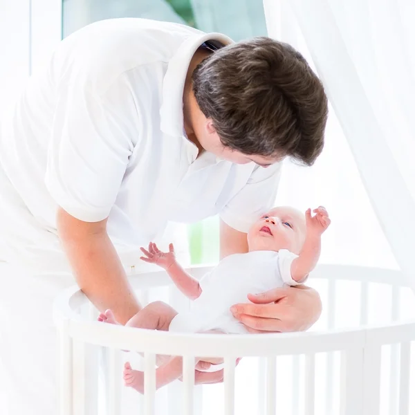 Joven padre sonriente poniendo a su bebé recién nacido — Foto de Stock