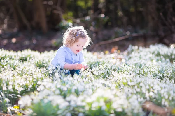 Meisje spelen met eerste Lentebloemen — Stockfoto