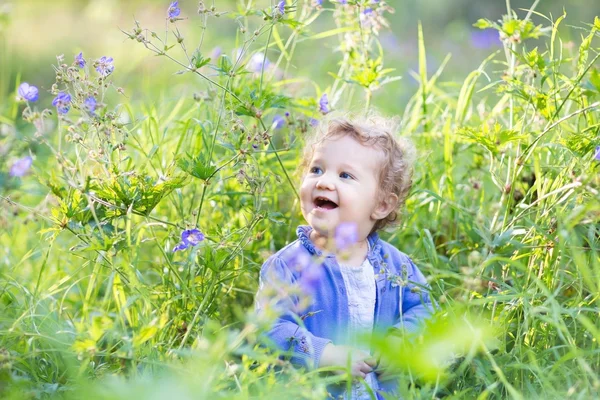 Güzel çiçekleri ile oynayan kız bebek — Stok fotoğraf