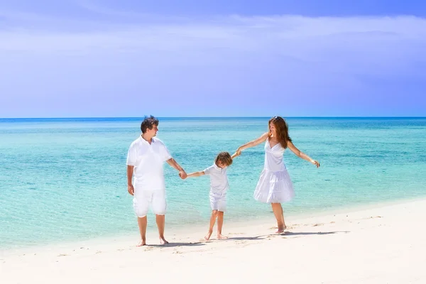 Familj på tre dansande på stranden — Stockfoto