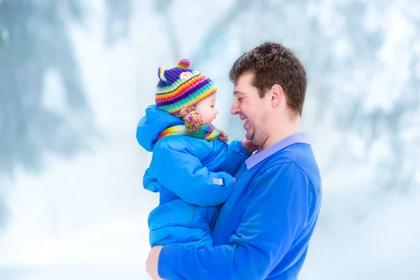 雪に覆われた公園で彼の赤ちゃんと遊ぶことの父 — ストック写真