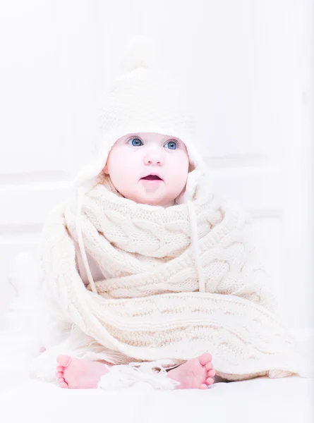 Funny baby sitting in a white bedroom — Stock Photo, Image