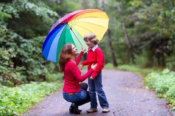 Mother and son under a colorful umbrella — Stock Photo, Image