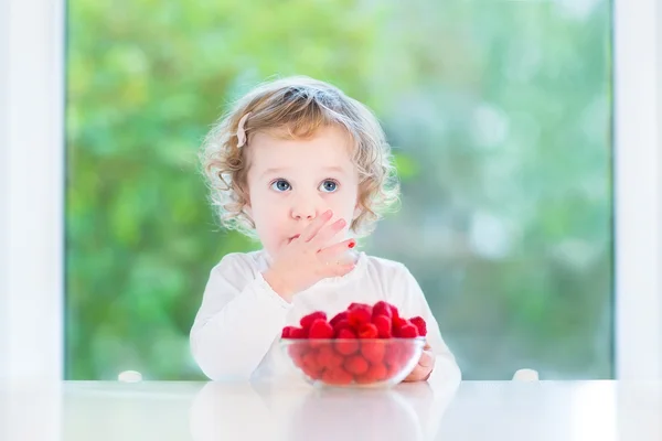 Linda niña comiendo frambuesas. —  Fotos de Stock