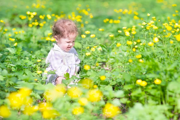 Bébé fille jouer avec des fleurs jaunes — Photo