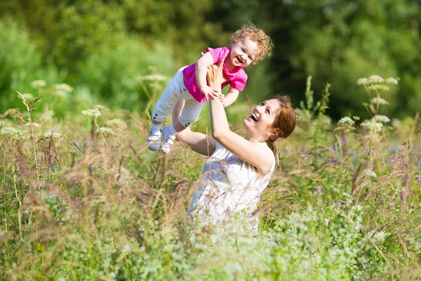 Madre sosteniendo a su hija cansada en un parque —  Fotos de Stock