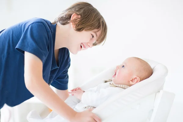 Boy talking to his newborn baby brother — Stock Photo, Image