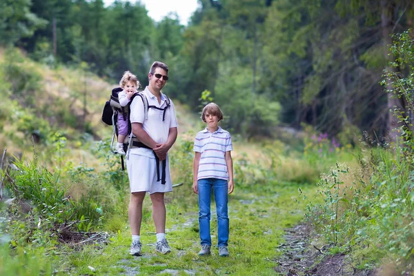 Caminhadas familiares jovens felizes em uma bela floresta de outono — Fotografia de Stock