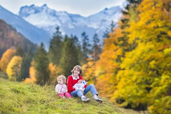 Three children playing after hiking in beautiful snow covered mountains — Stock Photo, Image