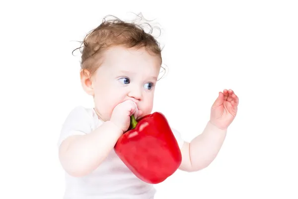 Büyük bir kırmızı pul biber ile oynayan bebek — Stok fotoğraf