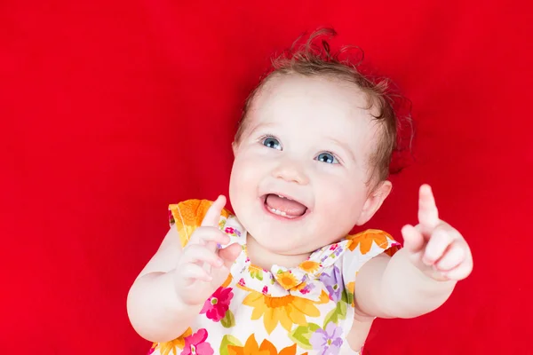 Baby flicka som leker på en röd filt — Stockfoto