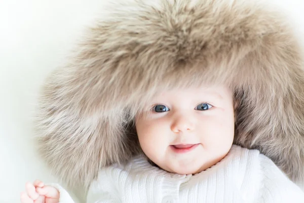 Baby wearing a big fur hat — Stock Photo, Image