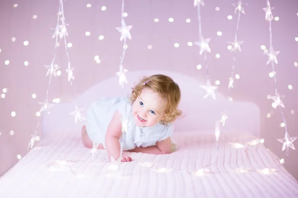 Adorable niña jugando en una cama —  Fotos de Stock