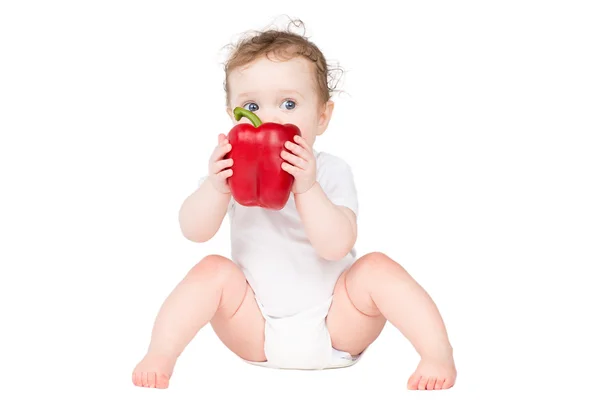 Baby biting on a big red paprika — Stock Photo, Image