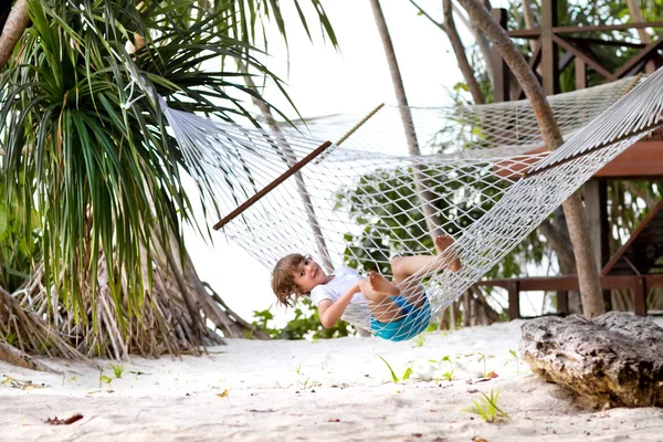 Мальчик отдыхает в гамаке на пляже — стоковое фото