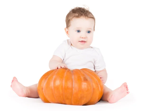 Baby girl playing with a big pumpkin — Stock Photo, Image