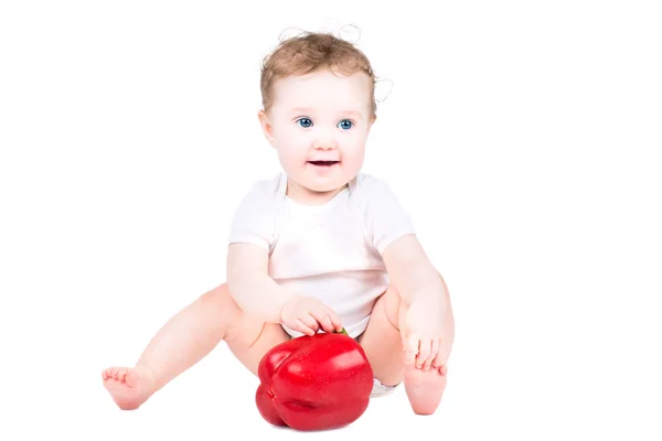 Kleines Baby spielt mit einem großen roten Paprika — Stockfoto