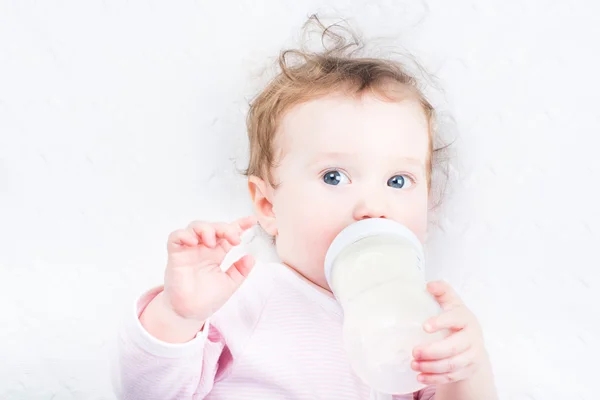 Bébé fille boire du lait dans un biberon — Photo