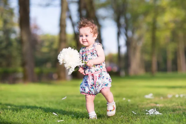 Flicka som leker med en stor vit aster blomma — Stockfoto