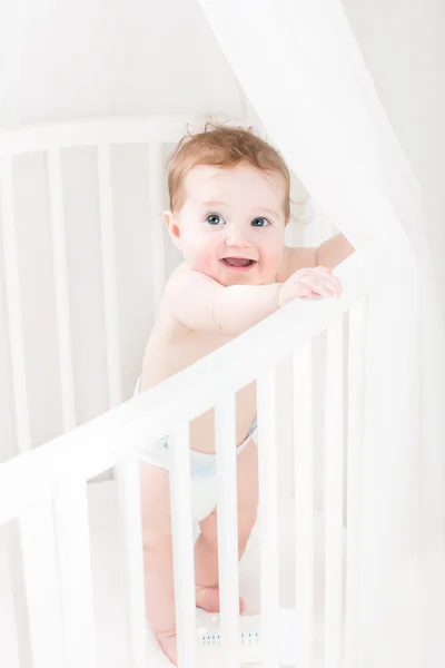 Funny baby  playing in its crib — Stock Photo, Image