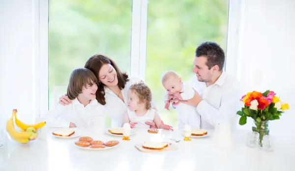 Jeune famille avec trois enfants prenant le petit déjeuner — Photo