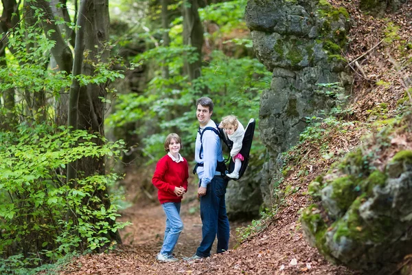 Mladá rodina, pěší turistiku v krásné podzimní Les — Stock fotografie