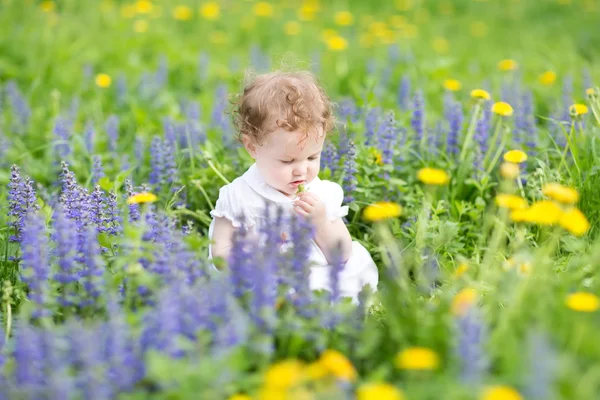 Güzel küçük bir kız çiçekleri ile oynama — Stok fotoğraf