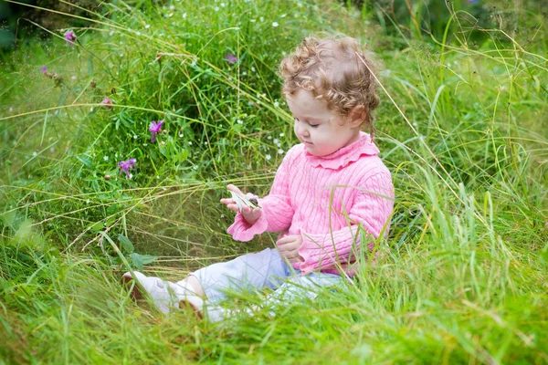 Ragazza che gioca con una lumaca in giardino — Foto Stock