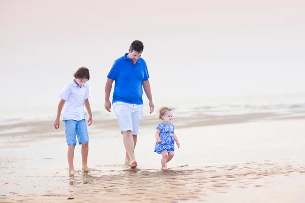 Vader met zijn zoon en peuter meisje wandelen op het strand — Stockfoto