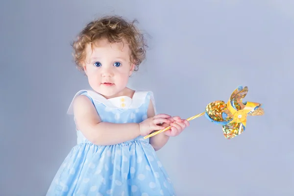 Hermosa niña jugando con un juguete de viento — Foto de Stock