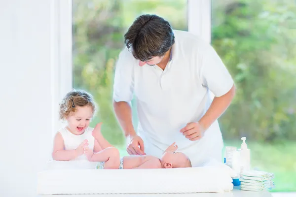 Pasgeboren baby kijken naar zijn vader en peuter zus — Stockfoto