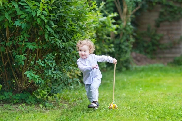 Baby flicka som leker med en träleksak — Stockfoto