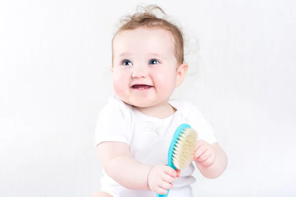 Bir saç fırçası ile oynayan kız bebek — Stok fotoğraf