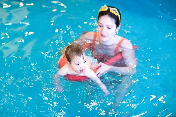 Little baby swimming in a pool with her mother Royalty Free Stock Photos