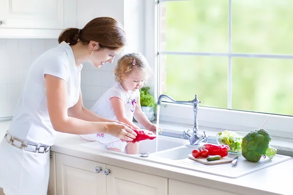 Moeder en haar dochter groenten wassen Stockfoto