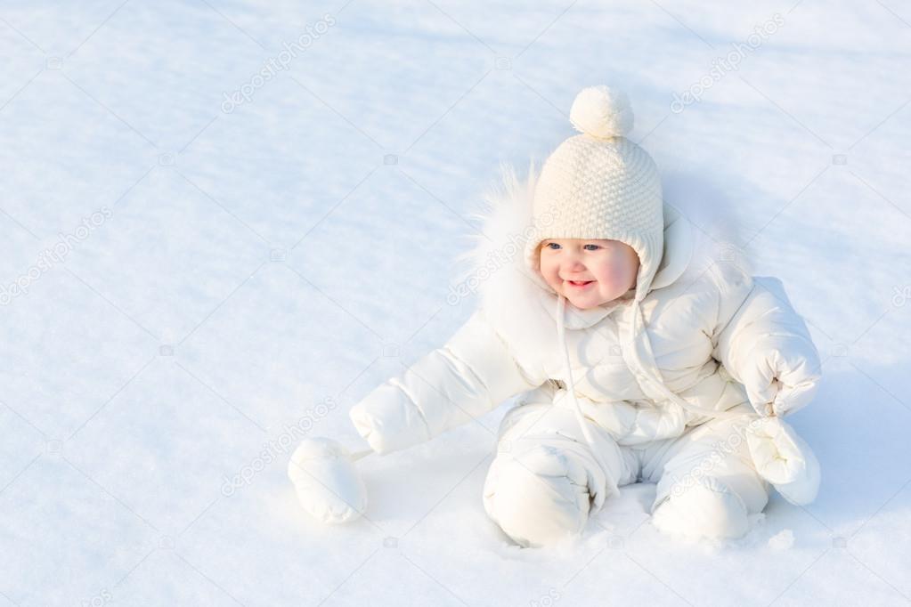 little baby sitting in fresh snow