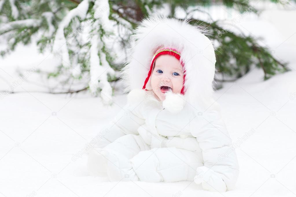 Little baby sitting in fresh snow