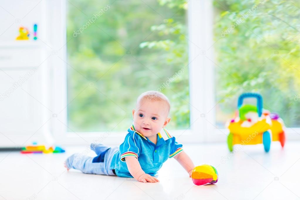 Adorable baby boy playing with a colorful ball and toy car