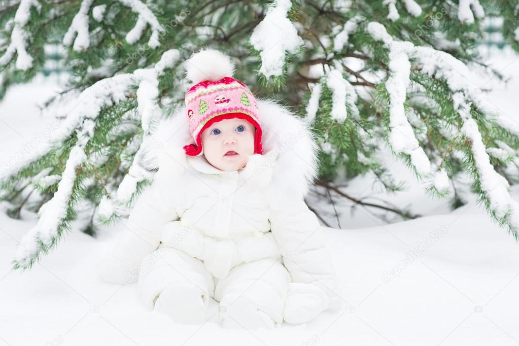 Little baby sitting in fresh snow