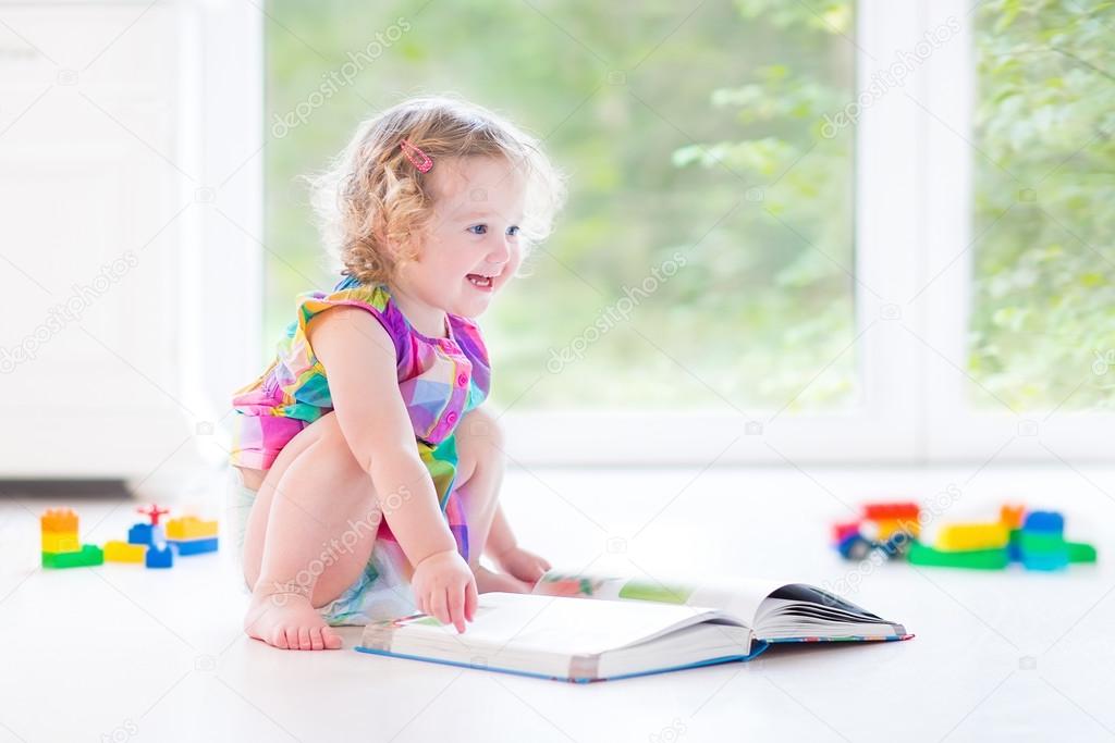 Girl with blond curly hair reading a book