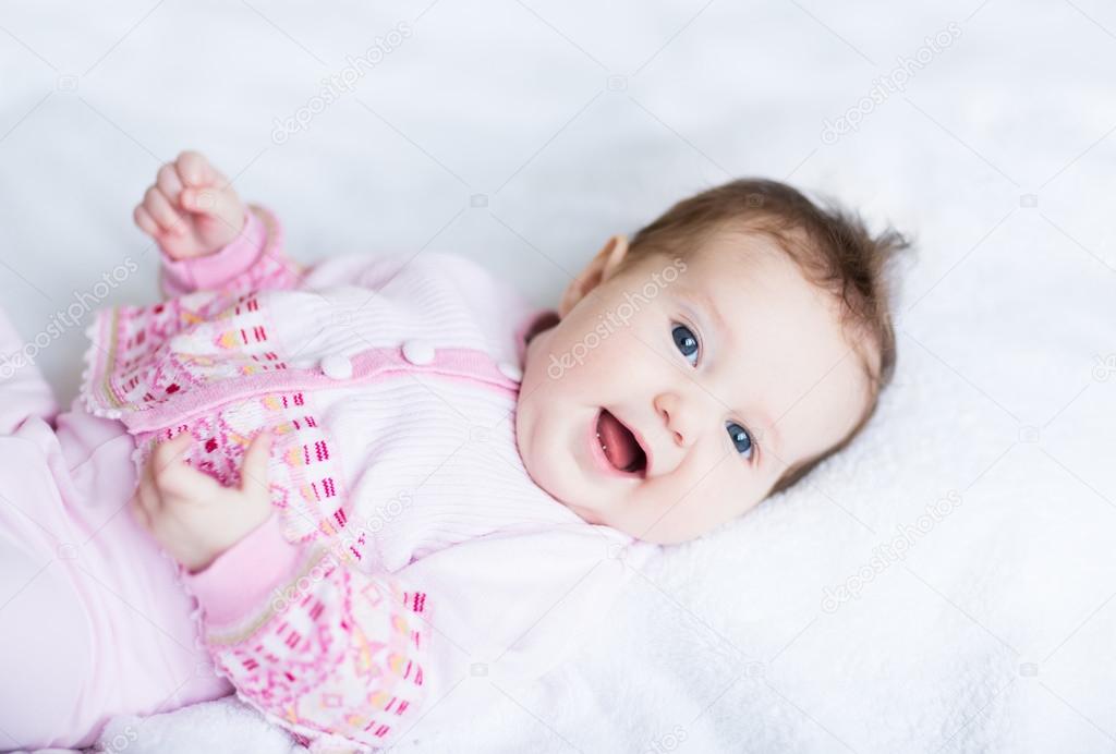 laughing baby girl on a white blanket
