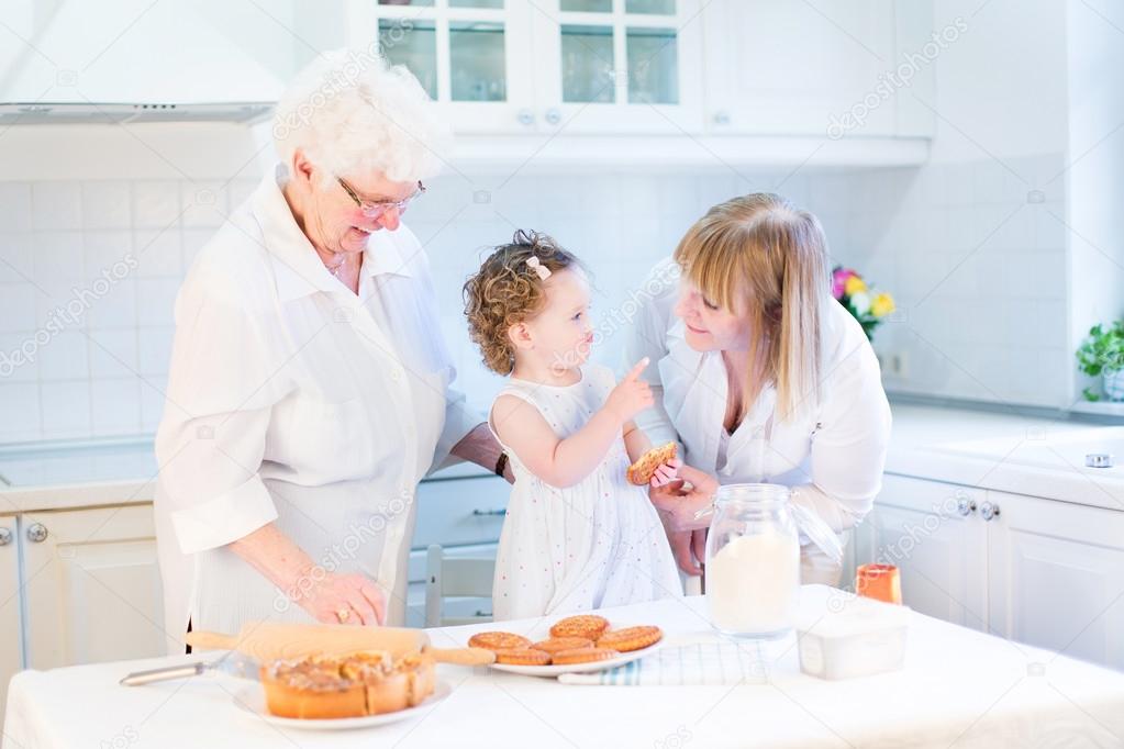 Toddler girl playing in a kitchen with her grandmothers