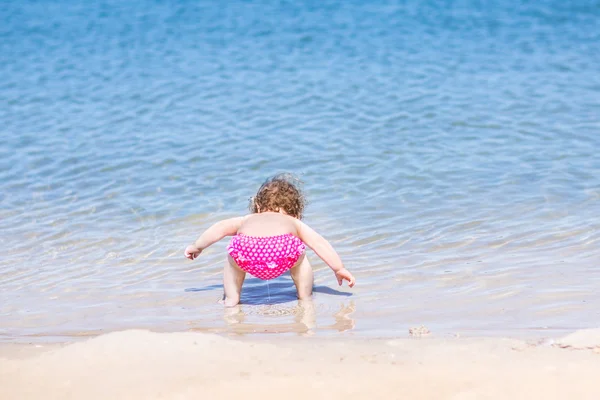 Su bir plajda oynayan bebek — Stok fotoğraf