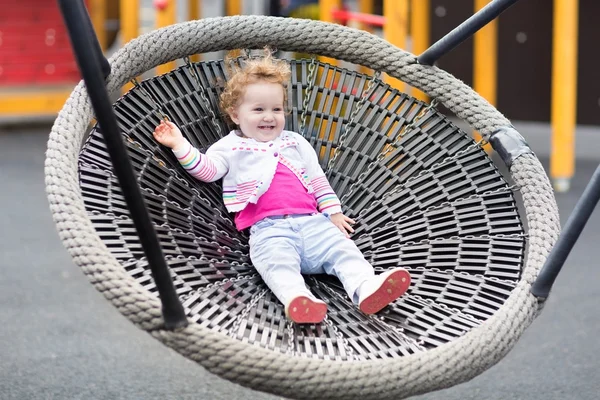 Baby flicka avkopplande på en gunga — Stockfoto