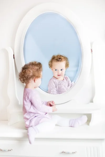 Girl with looking at her reflection — Stock Photo, Image